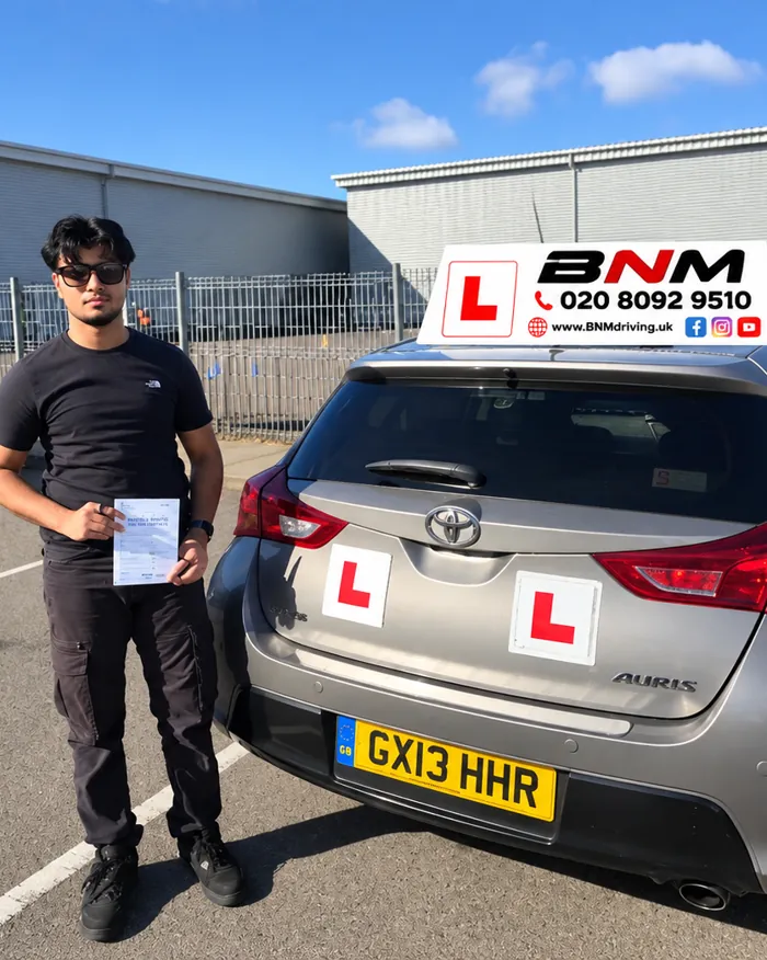 Learner holding a pass certificate beside a BNM Toyota with L plates